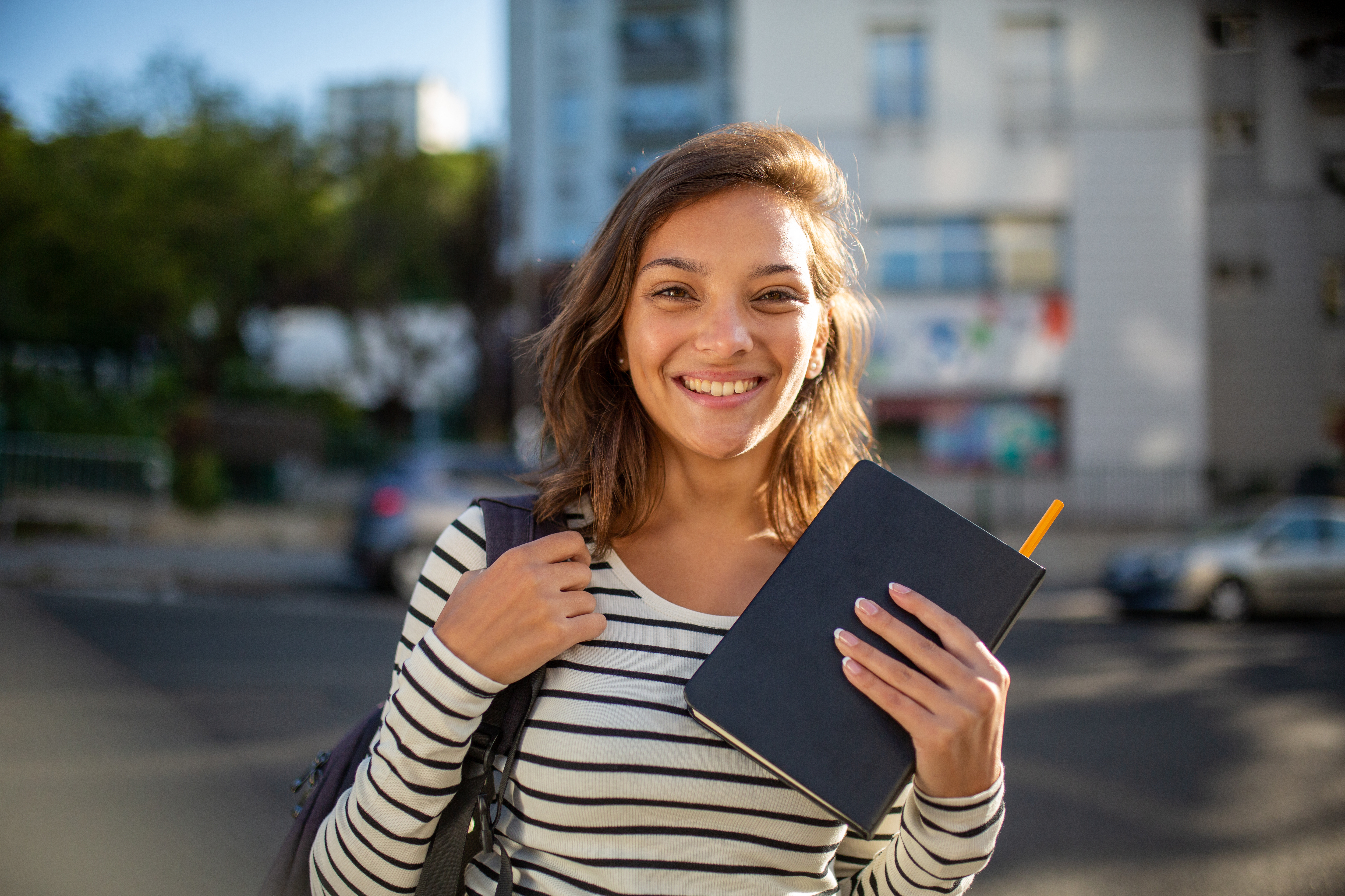 Close,Up,Portrait,Smiling,Female,Student,With,Bag,And,Book